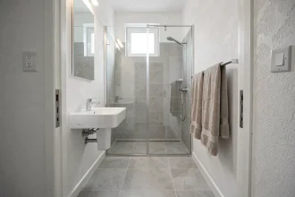 Petite salle de bain moderne de 4 m² avec douche à l'italienne, vasque suspendue et carrelage gris clair illustrant une surface standard