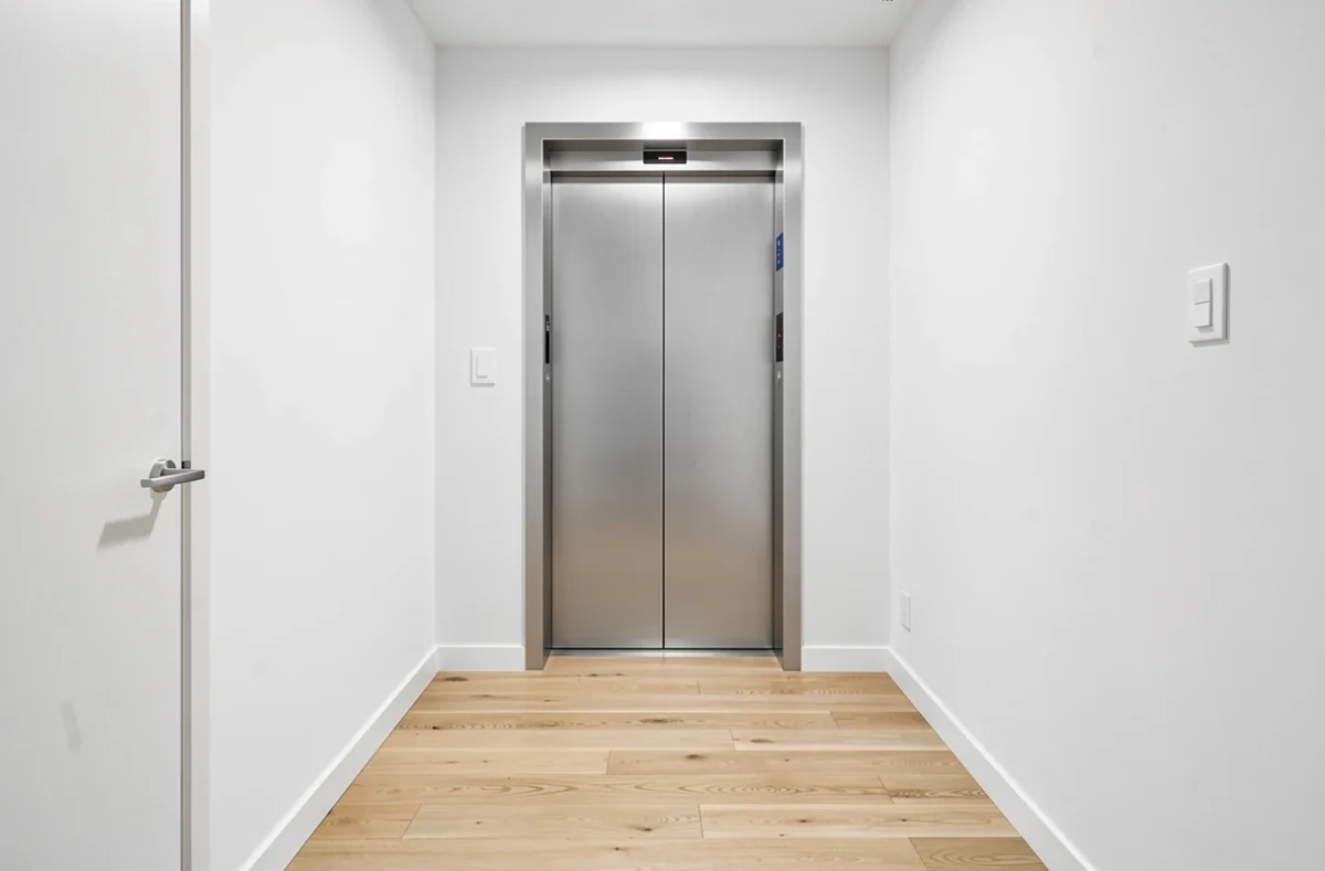 Porte d'ascenseur ouverte sur un palier d'immeuble résidentiel